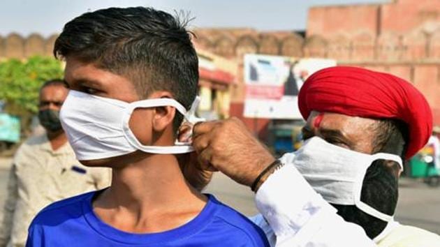 A social worker puts a mask on a boy during an awareness drive on the coronavirus disease (Covid-19) in Bikaner in this file photo.(PTI Photo)