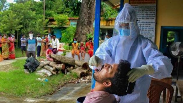 A health worker collects swab sample of a villager for Covid-19 test in Manipur. (PTI) A health worker collects swab sample of a villager for Covid-19 test in Manipur. (PTI)