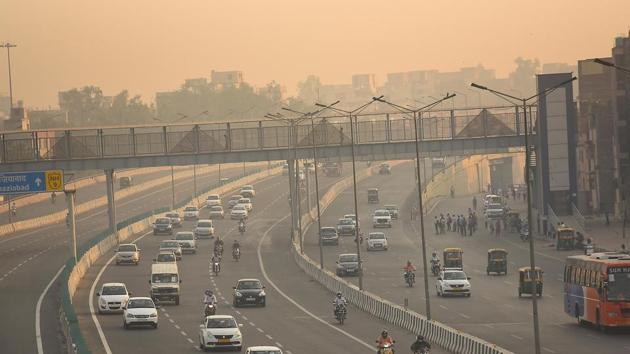 Cars are seen on haze covered NH-24 road as air pollution level rises, near Akshardham Temple in New Delhi on Monday.(Raj K Raj/HT Photo)