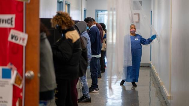 A poll worker walks past people casting their votes in New Orleans, Louisiana on October 16. So far the turnout has been lopsided, with Democrats outvoting Republicans by a 2:1 ratio in the 42 states included in the Associated Press count. Republicans have been bracing themselves for this early Democratic advantage for months, as they’ve watched President Donald Trump rail against mail-in ballots and raise worries about fraud. (Kathleen Flynn / REUTERS)