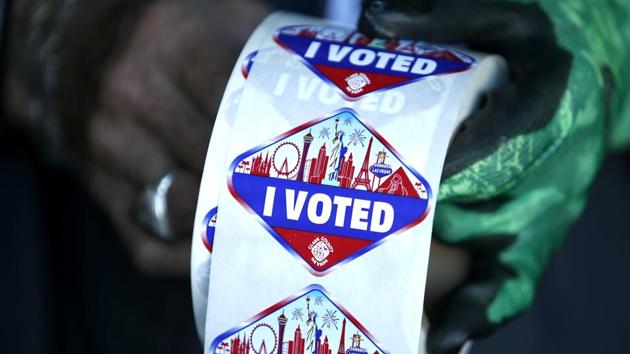 A poll worker displays "I Voted" stickers during the first day of early voting in Las Vegas on October 17. Republicans argue that signs of enthusiasm are meaningless — Democratic early voters are people who would have voted anyway. But an AP analysis of the early vote shows 8% of early voters had never cast a ballot before, and 13.8% had voted in half or fewer of previous elections for which they were eligible. (Steve Marcus / Las Vegas Sun via AP)