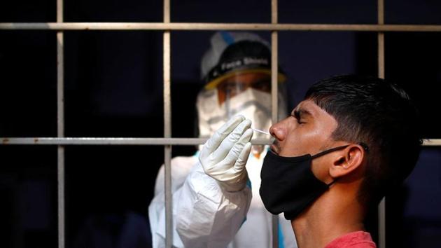 A man reacts as a healthcare worker collects a swab sample amidst the spread of the coronavirus disease at a testing centre, in New Delhi.(REUTERS)