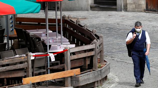 In picture - Man wearing a face mask walks past a terrace on Brussels Grand Place (REUTERS) In picture - Man wearing a face mask walks past a terrace on Brussels Grand Place (REUTERS)