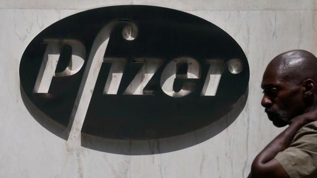 A man walks past a sign outside Pfizer Headquarters in the Manhattan borough of New York City, New York (REUTERS/Carlo Allegri/File Photo)