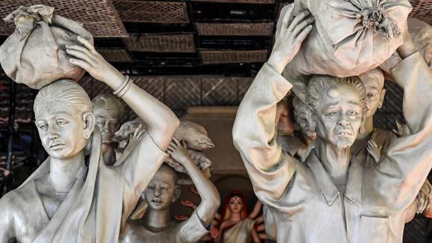An idol of Hindu deity Durga (back, centre) and models of migrant workers are used as a pandal theme in Kolkata on October 17. Some organising committees in West Bengal are highlighting the plight of migrant workers to create awareness about the migrant exodus during the nationwide lockdown imposed on March 25 to fight the coronavirus disease, HT reported. (Dibyangshu Sarkar / AFP)
