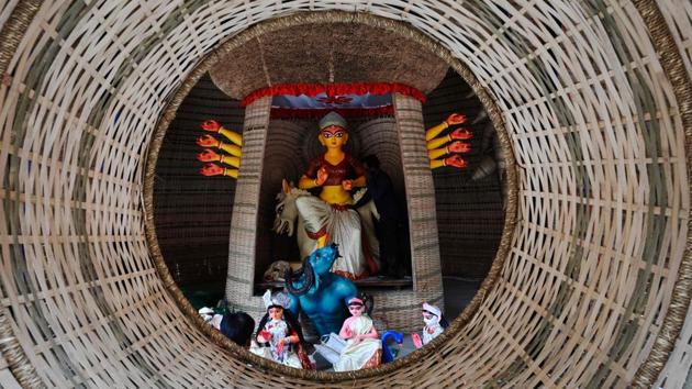 An artisan works on an idol of Hindu deity Durga at a makeshift workshop in Kolkata on October 18. (Dibyangshu Sarkar / AFP)