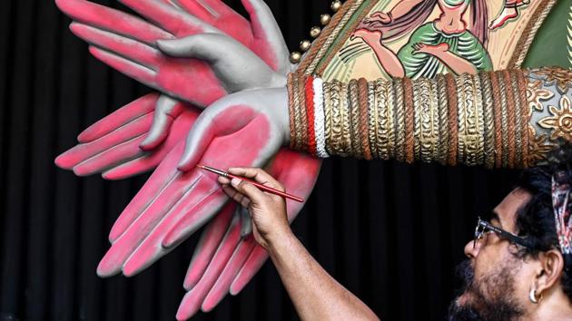 Renowned sculptor and painter Sanatan Dinda gives finishing touches to an idol of Hindu deity Durga at a makeshift workshop in Kolkata on October 17. (Dibyangshu Sarkar / AFP)