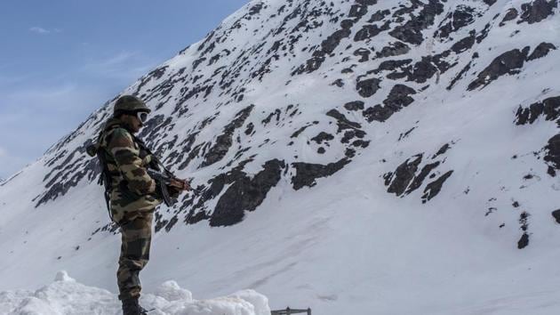 Indian army trooper stands guards the snow-cleared Srinagar-Leh highway in Zojila, 108 KM far from Srinagar.(Getty Images) Indian army trooper stands guards the snow-cleared Srinagar-Leh highway in Zojila, 108 KM far from Srinagar.(Getty Images)