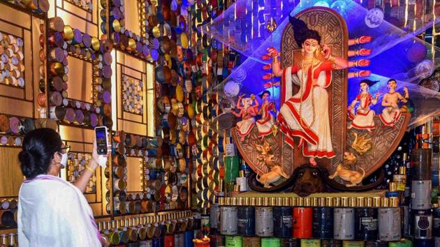 West Bengal Chief Minister Mamata Banerjee takes a picture after inaugurating a Durga Puja pandal in Kolkata on October 18. While most of the big pujas in Kolkata and its suburbs have been inaugurated by the CM herself, she urged pandal-hoppers and puja organisers to avoid crowding, HT reported. (PTI)