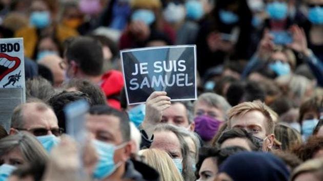 People gather at the Place de la Republique in Paris, to pay tribute to Samuel Paty, the French teacher who was beheaded on the streets of the Paris suburb of Conflans-Sainte-Honorine, France.(Reuters)