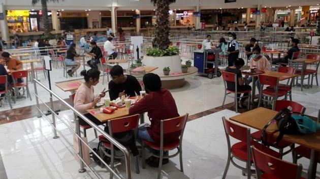 People eat at a food court at a mall in Mumbai after they reopened amidst the spread of the coronavirus disease (Covid-19) in this file photo. (Reuters Photo)
