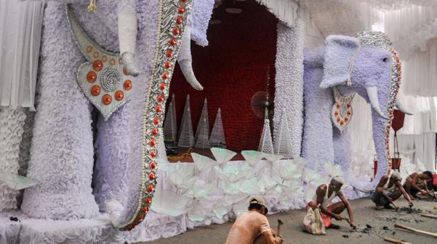 Workers construct a pandal ahead of the Durga Puja festival in Kolkata on October 19. Every year, nearly 37,000 pandals are set up in West Bengal, HT reported. (PTI)