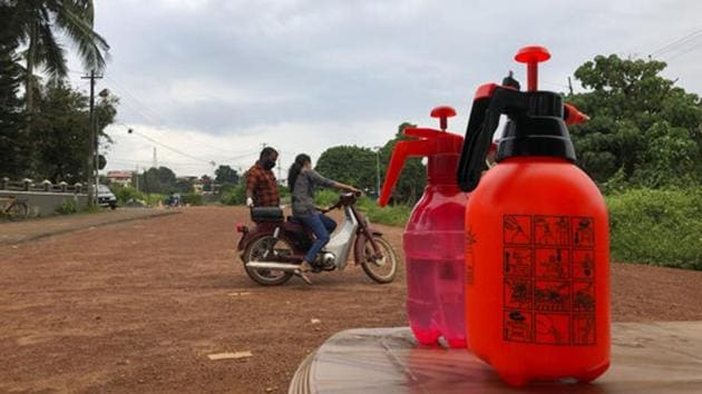 A driving school instructor trains a woman to ride a two wheeler, while bottles of sanitizers stand on a table at a training ground in Kochi on October 16. The health ministry notes that 75% of new confirmed cases are still being registered from 10 states and Union territories. Maharashtra, Karnataka, and Kerala are registering the highest incidences with just over 5,000 cases each. (R S Iyer / AP)