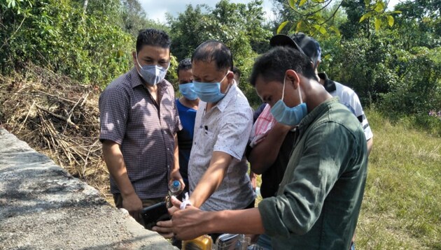 Meghalaya minister Hamletson Dohling (in white T-shirt) near a tank of uranium effluents in a remote village in South West Khasi Hills.(HT PHOTO)