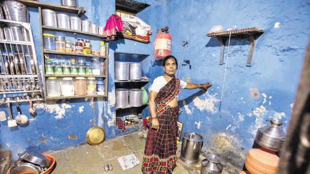 Asha Danke shows the mark on her kitchen wall where flood waters reached during the floods in Pandharpur, on Tuesday.(PRATHAM GOKHALE/HT)