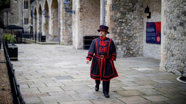 Ravenmaster Skaife walks to the raven cages at the Tower of London in central London on October 12. Skaife, who has looked after the ravens for the last 14 years, says that the ravens are readapting to seeing visitors again and hopes that life will be restored to normal soon. (Tolga Akmen / AFP)