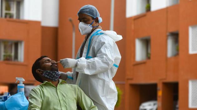 A health worker collects a swab sample from a man for coronavirus testing, at Pandit Deen Dayal Upadhyaya Marg, in New Delhi on Sunday, October 18, 2020.(Amal KS/HT PHOTO)