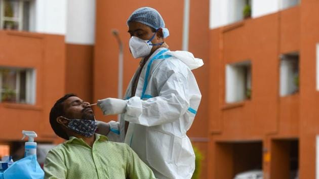 A health worker collects a swab sample from a man for coronavirus testing, at Pandit Deen Dayal Upadhyaya Marg, in New Delhi. (Amal KS/HT PHOTO) A health worker collects a swab sample from a man for coronavirus testing, at Pandit Deen Dayal Upadhyaya Marg, in New Delhi. (Amal KS/HT PHOTO)