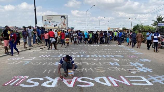 A demonstrator paints ‘End Sars,’ referring to the Special Anti Robbery Squad police unit, on a street during the protest in Lagos on October 20. Thousands of Nigerians have demonstrated in protests that initially focused on the SARS, that rights groups had for years accused of extortion, harassment, torture and murders, Reuters reported. (Seun Sanni / REUTERS)