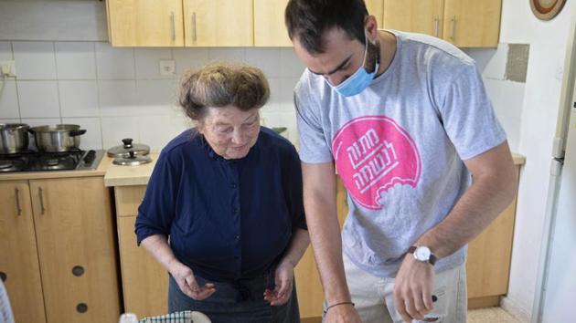 Sonia Rozenblatt, 85, tastes a cake made for her by Israeli volunteer Din Belz. (AP) Sonia Rozenblatt, 85, tastes a cake made for her by Israeli volunteer Din Belz. (AP)