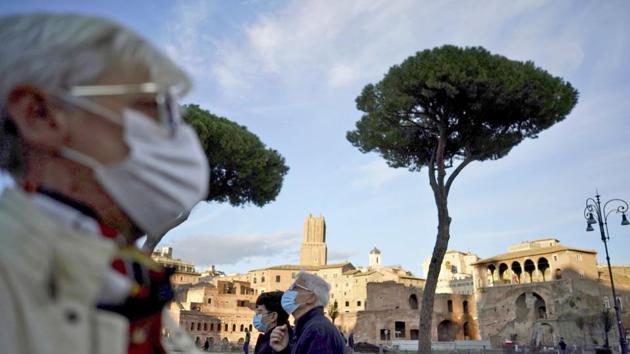People wearing masks take a walk in Rome. (AP) People wearing masks take a walk in Rome. (AP)