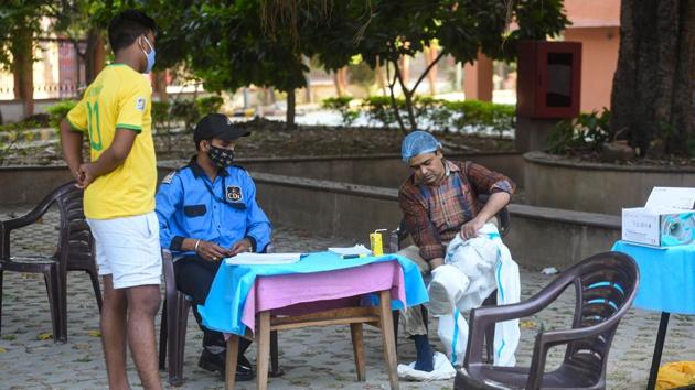 A health worker takes off a PPE suit after collecting swab samples for Covid-19 tests at Pandit Deen Dayal Upadhyaya Marg in New Delhi on October 18. Over the past week, more than 27% of the tests were done using RT-PCR method up from just about 18% in September when the Delhi government had massively scaled-up testing along with the rising cases of the infection, HT reported. (Amal KS / HT Photo)