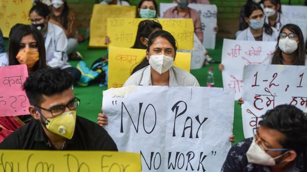 Resident doctors association members of Hindu Rao Hospital hold placards during a protest demanding their outstanding remuneration, at Jantar Mantar in New Delhi on Thursday.(PTI)