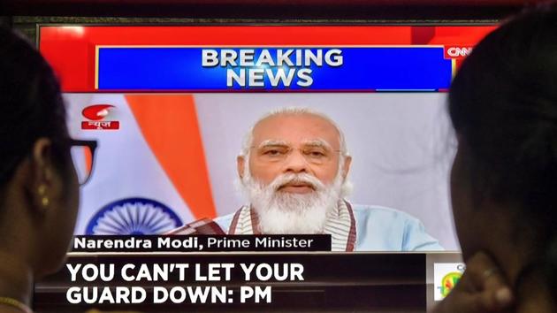 A family watches Prime Minister Narendra Modi addressing the nation on television on October 20. (AFP) A family watches Prime Minister Narendra Modi addressing the nation on television on October 20. (AFP)