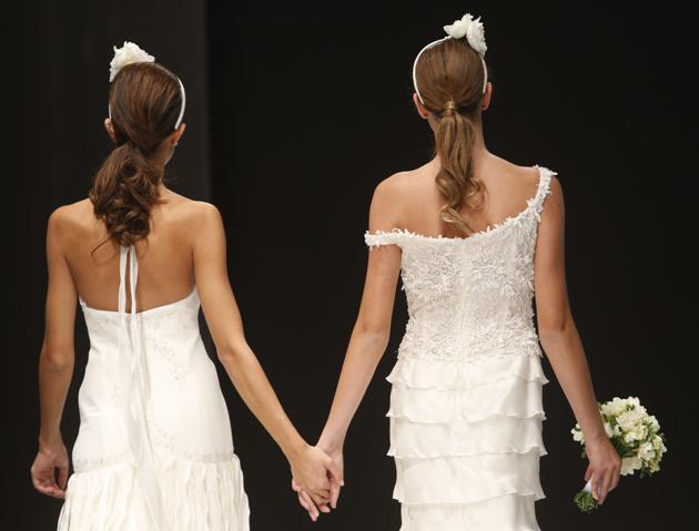 FILE -- In this Thursday, Oct. 23, 2014 file photo, models hold hands on the catwalk during a wedding fashion show with same-sex couples, dubbed "The rainbow wedding fashion show", part of a 'wedding fair' taking place in Rome. Pope Francis endorsed same-sex civil unions for the first time as pope while being interviewed for the feature-length documentary “Francesco,” which premiered Wednesday, Oct. 21 2020 at the Rome Film Festival. (AP)