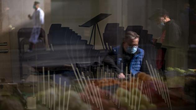 People are reflected on a restaurant window, closed due to a sharp resurgence of the coronavirus in Barcelona on October 20, 2020. Spain has doubled its Covid-19 case tally in just six weeks despite a series of increasingly stringent measures to control the country’s second wave of infections from the virus. (Emilio Morenatti / AP)