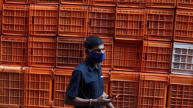 A man wearing a face mask walks past baskets stacked at a flower market in Mumbai on October 20. The BMC is conducting approximately 15,000 tests daily at the moment and the overall growth rate for Covid-19 in the city has come down from 8-10% in March-April to 0.69% in October, HT reported. (Francis Mascarenhas / REUTERS) A man wearing a face mask walks past baskets stacked at a flower market in Mumbai on October 20. The BMC is conducting approximately 15,000 tests daily at the moment and the overall growth rate for Covid-19 in the city has come down from 8-10% in March-April to 0.69% in October, HT reported. (Francis Mascarenhas / REUTERS)