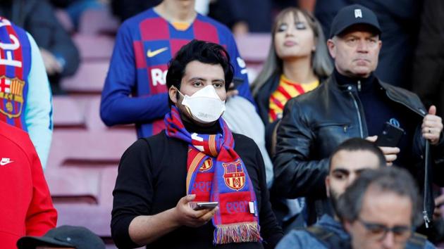 FILE PHOTO: Soccer Football - La Liga Santander - FC Barcelona v Real Sociedad - Camp Nou, Barcelona, Spain - March 7, 2020 A Barcelona fan wears a mask before the match due to the recent coronavirus outbreak REUTERS/Albert Gea/File Photo(REUTERS)