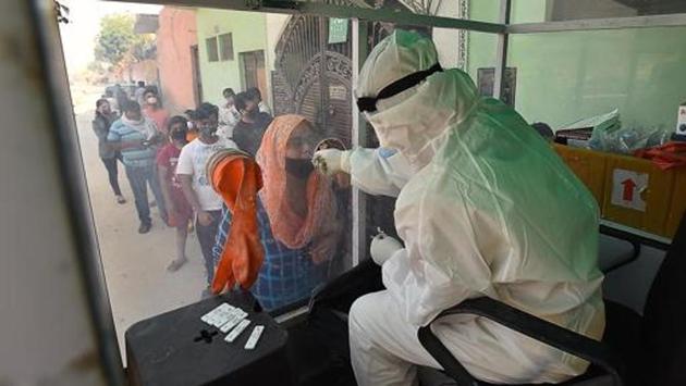A health worker collects a swab sample from a woman for coronavirus testing at a mobile Covid-19 testing van, at New Ashok Nagar, in New Delhi. (Raj K Raj/HT PHOTO) A health worker collects a swab sample from a woman for coronavirus testing at a mobile Covid-19 testing van, at New Ashok Nagar, in New Delhi. (Raj K Raj/HT PHOTO)