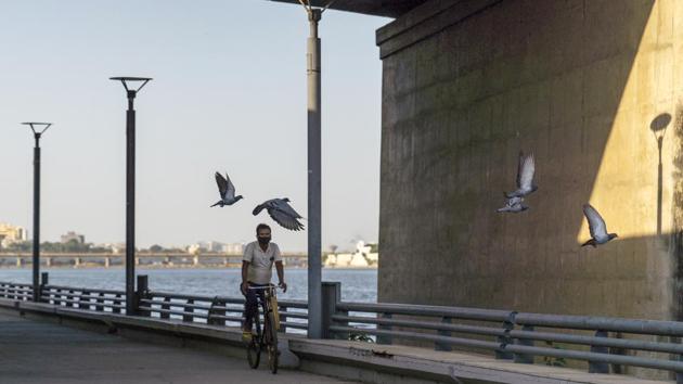 A cyclist rides along the near- empty Sabarmati Riverfront in Ahmedabad, India on October 22. Worst-hit in Asia, India has reported over 7.8 million infections, behind only the United States’ tally of 8.5 million, and nearly 118,000 deaths, versus 224,128 in the United States. Unlike the recent US surge, however, India’s slowdown saw the lowest daily caseload in nearly three months on October 24. (Sumit Dayal / Bloomberg)