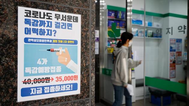 A woman walks past a poster encouraging people to get an influenza vaccine in Seoul, South Korea on October 23. The global death toll from Covid-19 could double to 2 million before a successful vaccine is widely used and could be even higher without concerted action to curb the pandemic, Ryan said at a news conference. (Kim Hong-Ji / REUTERS)