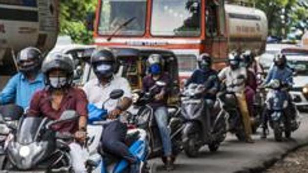 Commuters wearing masks wait at a traffic intersection in Kochi in Kerala amid the Covid-19 pandemic. (AP PHOTO.) Commuters wearing masks wait at a traffic intersection in Kochi in Kerala amid the Covid-19 pandemic. (AP PHOTO.)