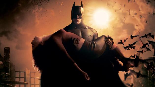 Christian Bale’s Batman carries Katie Holmes’ Rachel Dawes in Batman Begins.