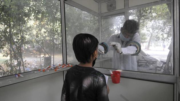 A health worker collects swab samples for coronavirus tests, at Sector 30 District Hospital, in Noida on Saturday.(Sunil Ghosh /HT Photo)