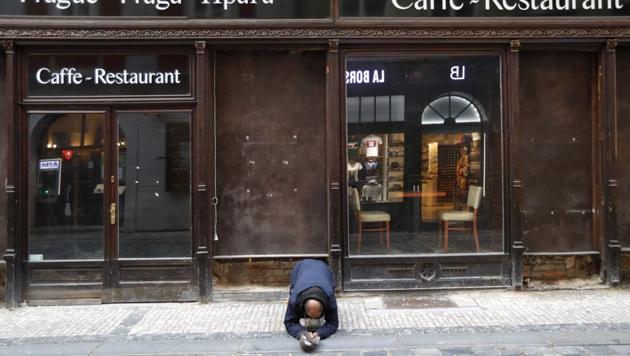 A beggar kneels in front of a closed restaurant in downtown Prague, Czech Republic. The coronavirus pandemic is gathering strength again in Europe and, with winter coming, its restaurant industry is struggling. (AP) A beggar kneels in front of a closed restaurant in downtown Prague, Czech Republic. The coronavirus pandemic is gathering strength again in Europe and, with winter coming, its restaurant industry is struggling. (AP)