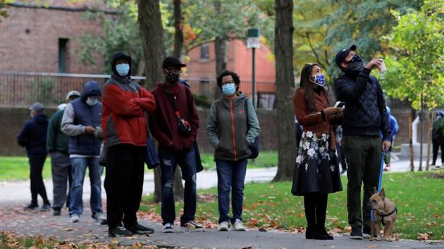 US Representative Alexandria Ocasio-Cortez stands in a queue with her partner Riley Roberts and dog Deco outside a polling station in The Bronx, New York City on October 25. According to the US Election Assistance Commission website, 57 million Americans had voted early or by mail in 2016. (Andrew Kelly / REUTERS)