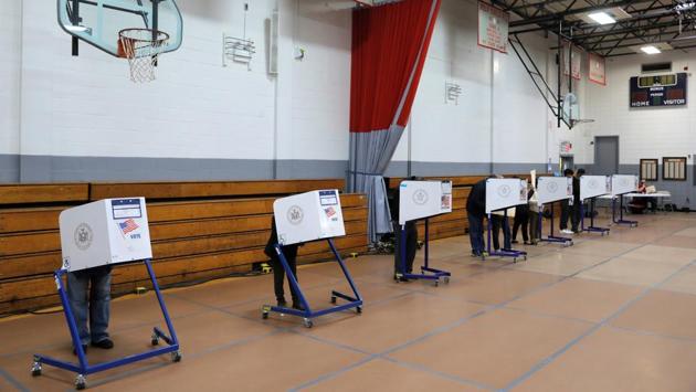 People fill ballots at a polling station in the Monsignor John D. Burke Memorial Gym in Staten Island, New York City on October 25. With seven days still to go before the November 3 poll, early voting in the 2020 US election has surpassed all the pre-election ballots from four years earlier, an independent vote monitor said on October 25, AFP reported. (Andrew Kelly / REUTERS)