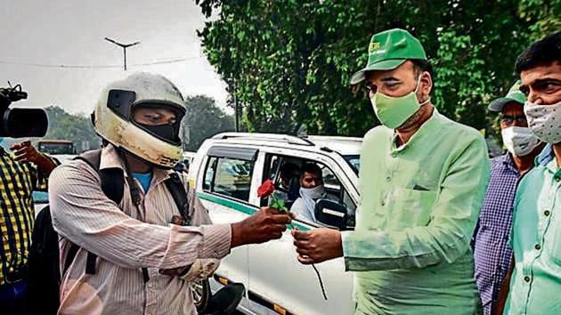 Environment minister Gopal Rai offers a flower to a commuter at Rajpath as part of the campaign.