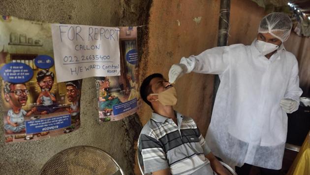 A health worker collects a swab sample to test for Covid-19 infection at Kalina in Mumbai on October 25. The 804 new cases recorded on October 26 is also the lowest daily cases recorded in Mumbai in the past two months, HT reported. (Satish Bate / HT Photo)