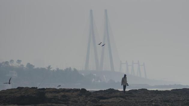 A man walks by Bandstand, in the backdrop of the Bandra-Worli sealink in Mumbai on October 24. The fatality rate also dropped in Maharashtra. Between September 1-25, there were 10,178 reported deaths due to Covid-19 disease. In the corresponding period in October, there have been 6,602 deaths, which is a 35% drop. (Satish Bate / HT Photo)