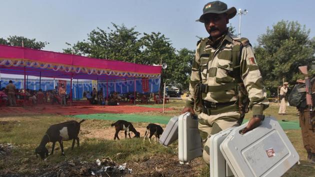 Security personnel seen carrying EVM machines on the eve of the first phase of Bihar Assembly election.(Parwaz Khan / Hindustan Times)