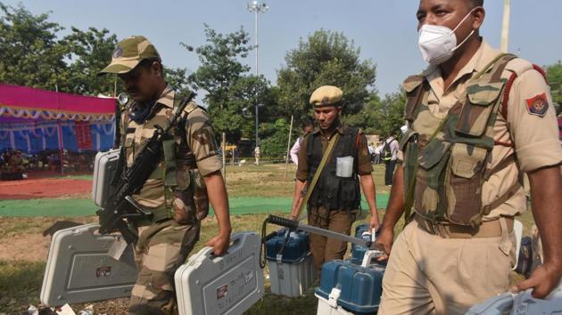 Security personnel seen carrying EVM machines on the eve of the first phase of Bihar Assembly election.(Parwaz Khan / Hindustan Times)