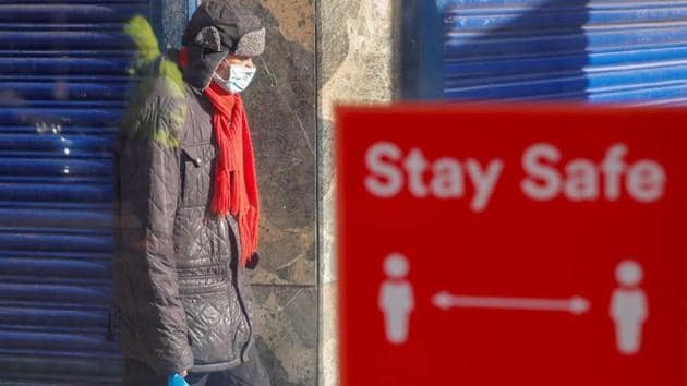FILE PHOTO: A person wearing a protective mask walks near a social distancing sign, amid the outbreak of the coronavirus disease (COVID-19), in Coventry, Britain October 25, 2020.(REUTERS)