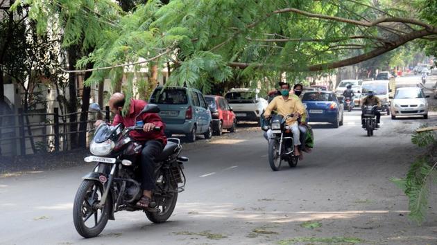 A motorist dodges a branch near Nakshatram Society in Pune on October 23. Covid-19 hotspots across Maharashtra reported fewer cases on October 26. Pune city reported 152 cases and one fatality, while its rural areas reported 108 new cases and two deaths. (HT Photo)