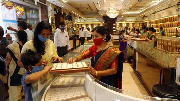 People shop at a jewellery store in Pune on October 25. There are 14 states and union territories including Rajasthan, Jharkhand, Andhra Pradesh, Telangana, Bihar, Odisha, Assam and Kerala where the Case Fatality Ratio (CFR) is lower than 1%, the ministry noted. (Rahul Raut / HT Photo)