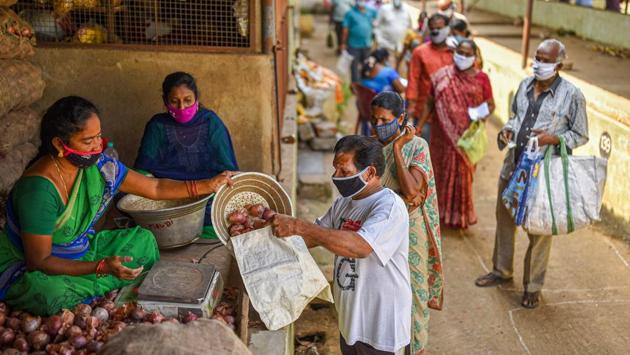 People wait in a queue to buy onions at a shop selling them at subsidized rates in Vijayawada on October 26. These latest numbers come amid a steep fall in the country’s new daily Covid-19 cases over the last few days. The previous spike of 45,149 was the lowest since that on July 23, when 45,720 infections were reported. (PTI)